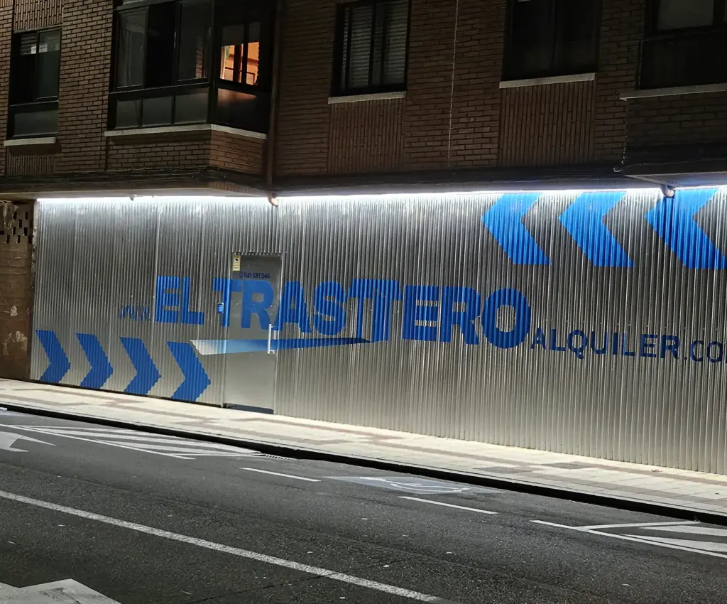 Fachada de El Trastero en León de noche, con el rótulo iluminado